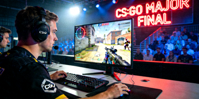 CS:GO Major锦标赛决赛现场 - 选手佩戴耳机专注比赛，大屏幕显示游戏第一视角